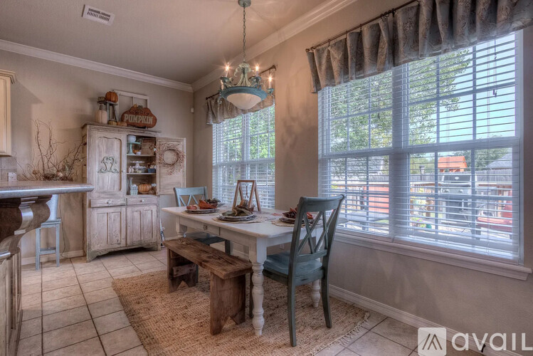 A kitchen with a table and chairs.