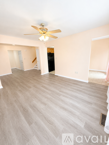 A spacious room with a ceiling fan and light fixture.