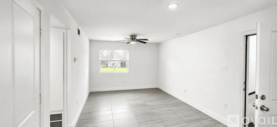 A spacious room with a ceiling fan and a window.