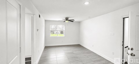A spacious room with a ceiling fan and a window.