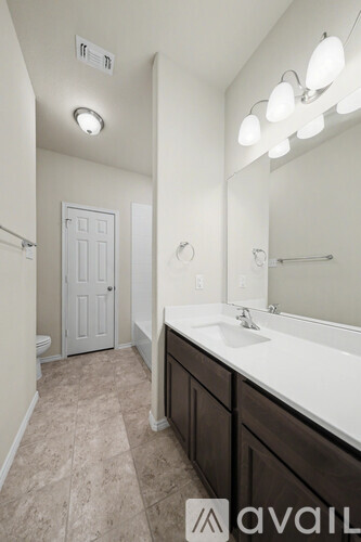 A spacious room with wooden flooring and white walls.