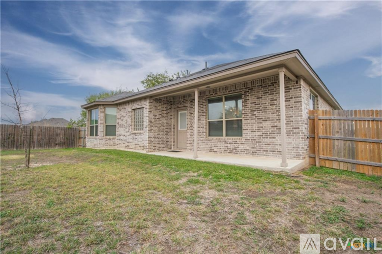 A house with a brown fence and a grassy yard.