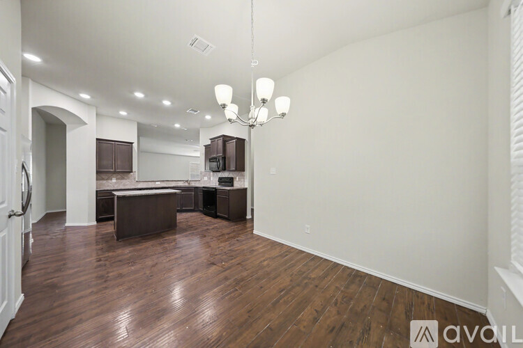 A kitchen with dark wood cabinets and a black stove top oven.