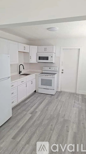 A kitchen with white appliances and cabinets.