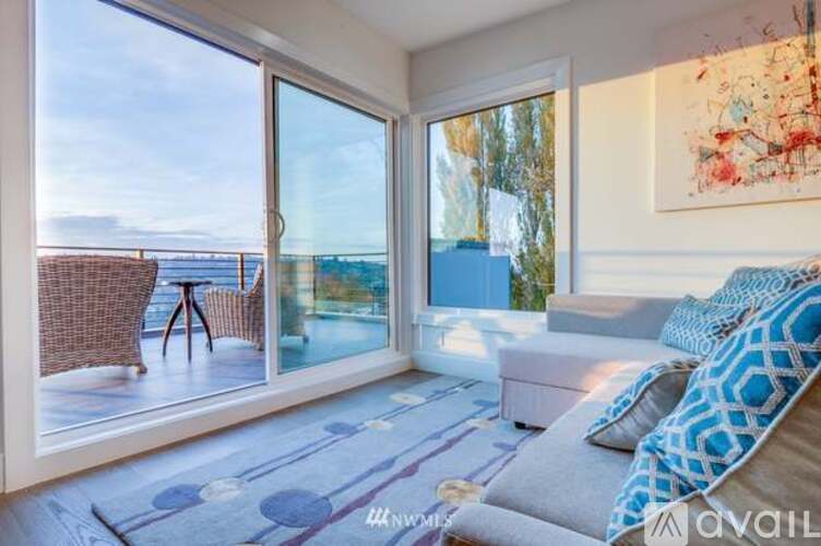 A living room with a couch and a view of the ocean through the windows.