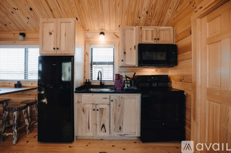 A kitchen with wooden cabinets and black appliances.