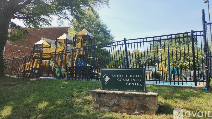 A sign for Emery Heights Community Center stands in front of a playground.