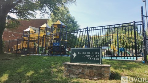 A sign for Emery Heights Community Center stands in front of a playground.