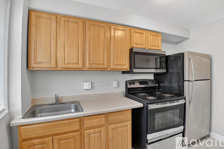A kitchen with wooden cabinets and black appliances.