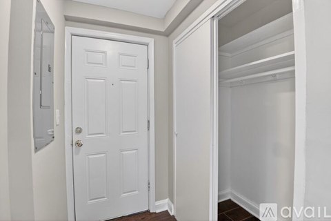 A white door is in a white room.