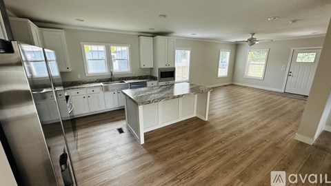 A kitchen with wooden floors and white cabinets is available for rent.