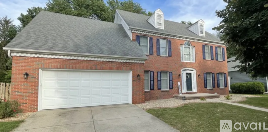 A red brick house with a white garage door.
