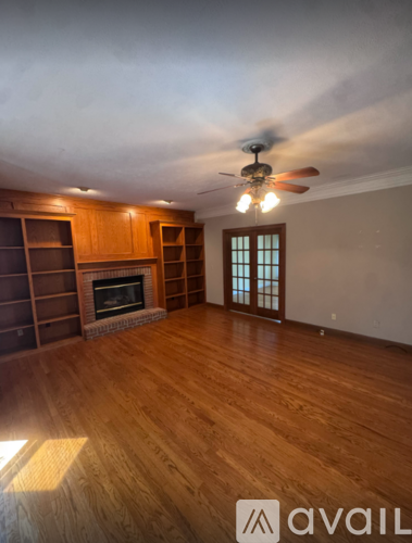 A kitchen with wooden cabinets and a black microwave oven.