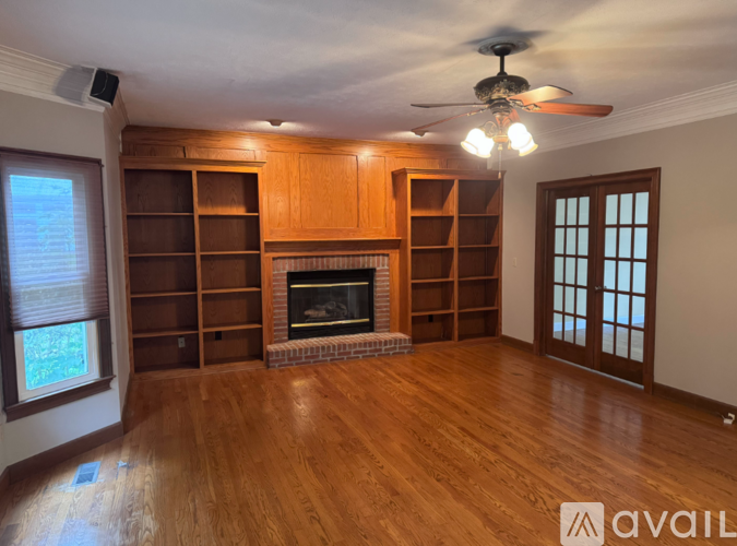A living room with a fireplace and wooden floors.