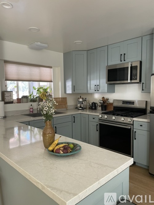 A kitchen with a white countertop and blue cabinets.