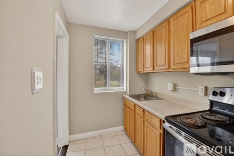 A kitchen with wooden cabinets and a black stove top oven.