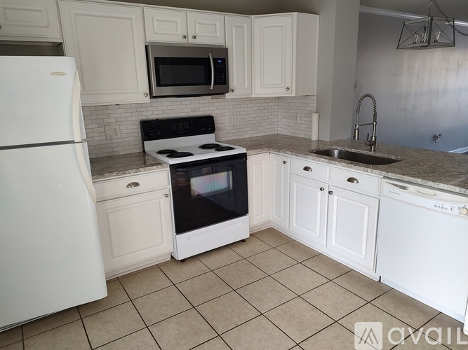 A kitchen with white appliances and cabinets.