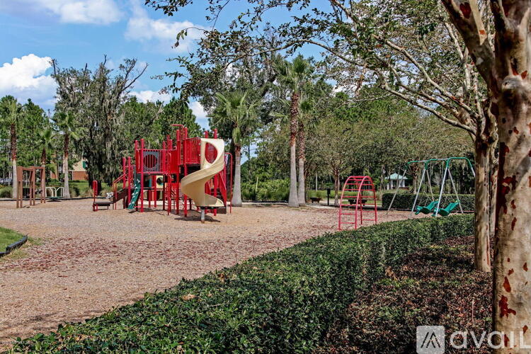 A playground with a red slide and green slide in the background.