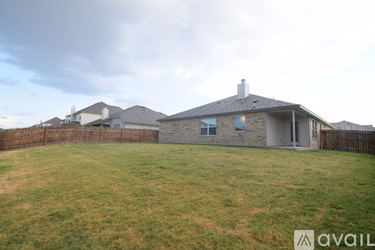 A house with a fence and a grassy yard is available for sale.
