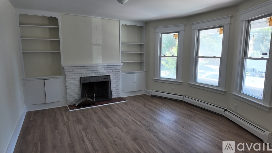 A living room with a fireplace and wood flooring.