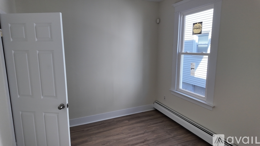 A room with a white door and a window with blinds.