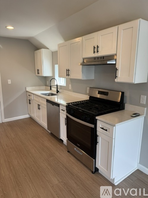 A kitchen with white cabinets and a black stove top oven.