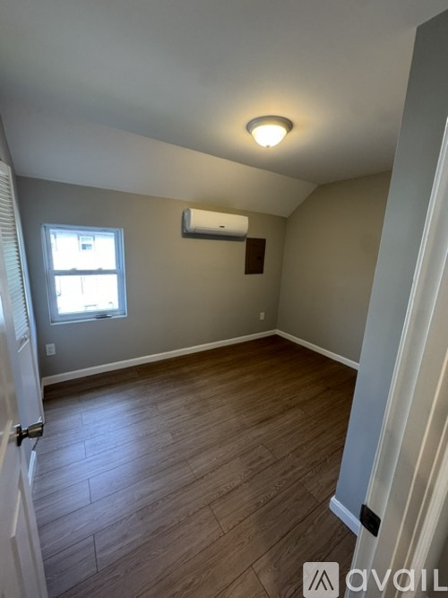 A room with a window and a wall-mounted air conditioner unit.
