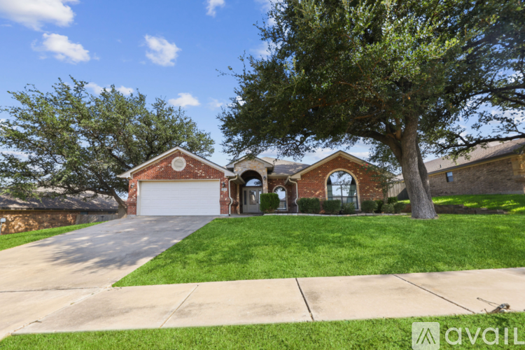 A house with a driveway and a tree in front.