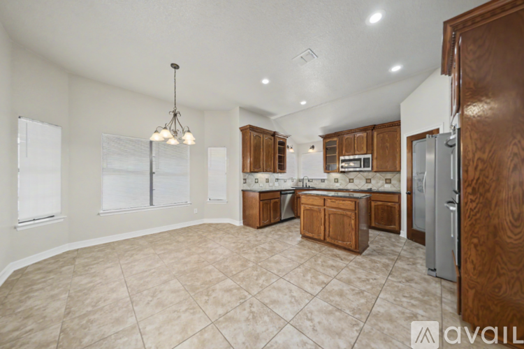 A kitchen with wooden cabinets and a tile floor.