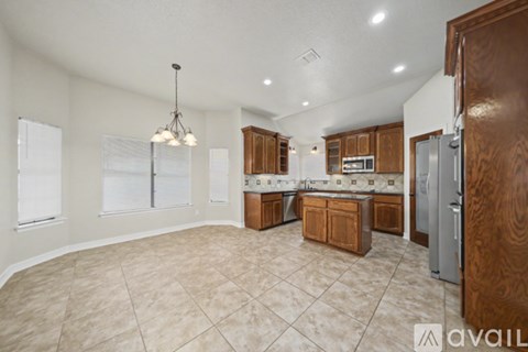 A kitchen with wooden cabinets and a tile floor.