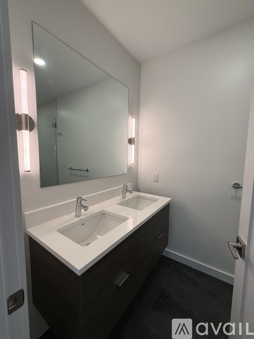 A bathroom with a white sink and a mirror above it.