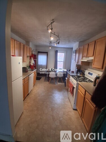 A kitchen with wooden cabinets and a white refrigerator.