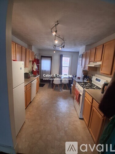 A kitchen with wooden cabinets and a white refrigerator.