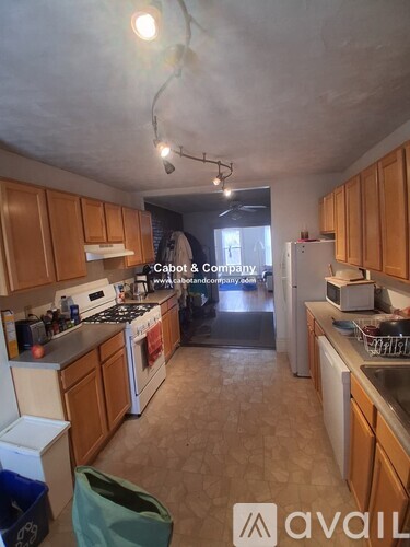 A kitchen with wooden cabinets and a white refrigerator.