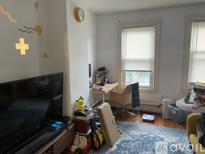 A living room with a television, a chair, and a rug.