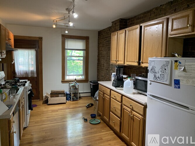 A kitchen with wooden cabinets and a white fridge.