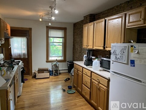 A kitchen with wooden cabinets and a white fridge.