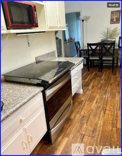 A kitchen with a red microwave on top of the counter.