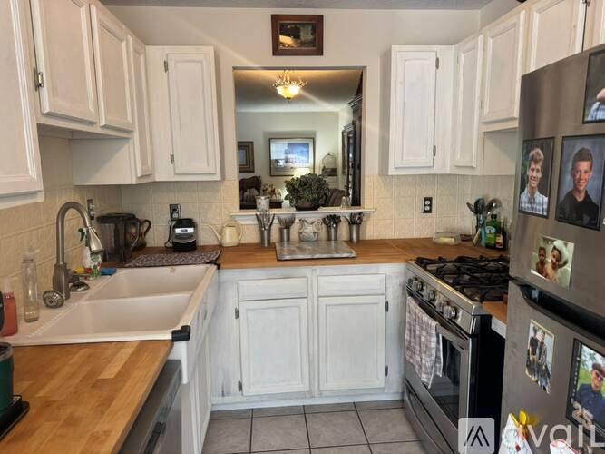 A kitchen with white cabinets and a wooden countertop.