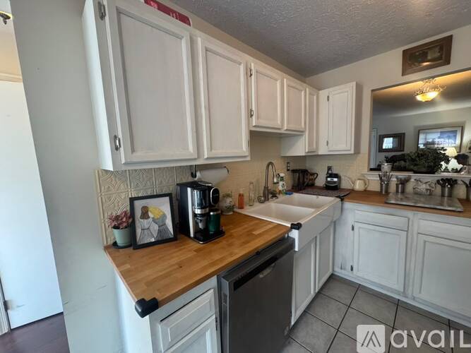 A kitchen with white cabinets and a wooden countertop.