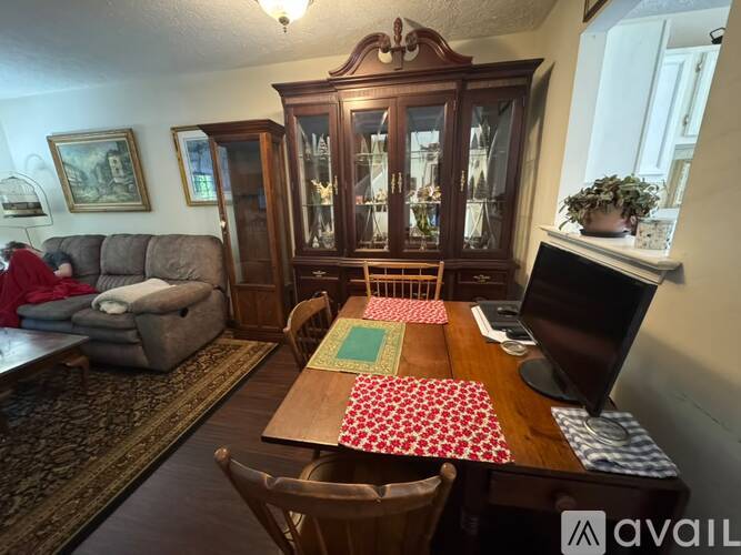 A dining room with a wooden table and chairs.