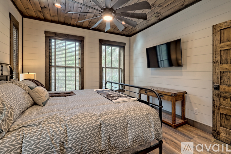 A bedroom with a large bed and a ceiling fan.