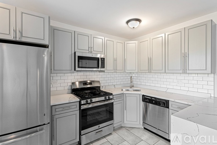 A kitchen with white cabinets and stainless steel appliances.