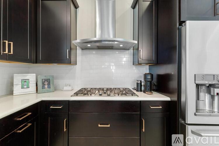 A kitchen with black cabinets and a white stove top.