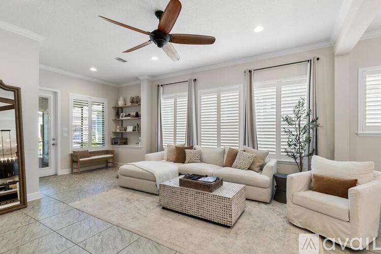 A living room with a white couch, a coffee table, and a ceiling fan.