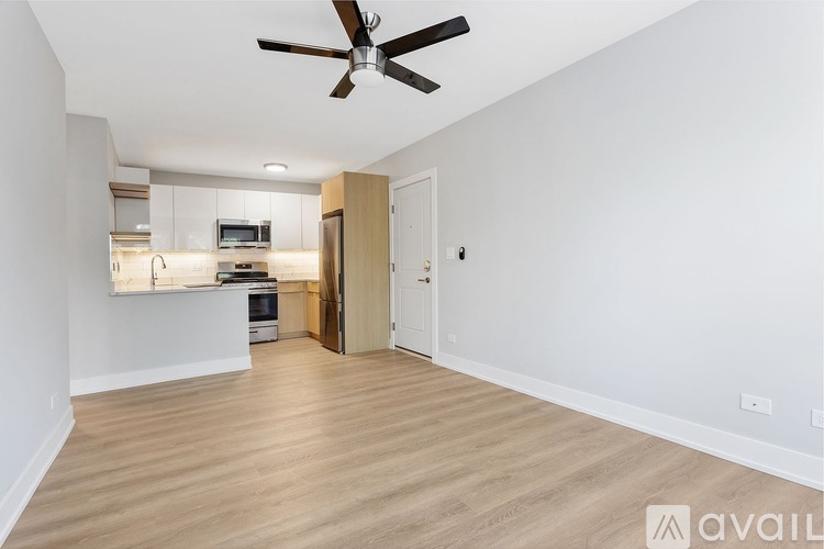 A spacious room with a ceiling fan and lighting fixtures.