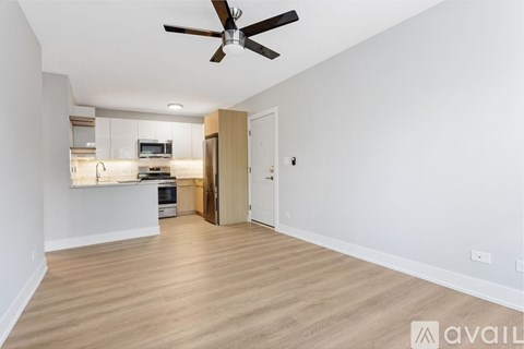 A spacious room with a ceiling fan and lighting fixtures.