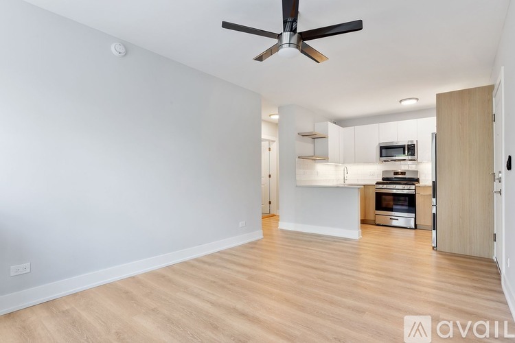 A spacious room with a ceiling fan and wooden flooring.