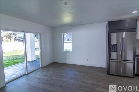 A kitchen area with a refrigerator and a window.