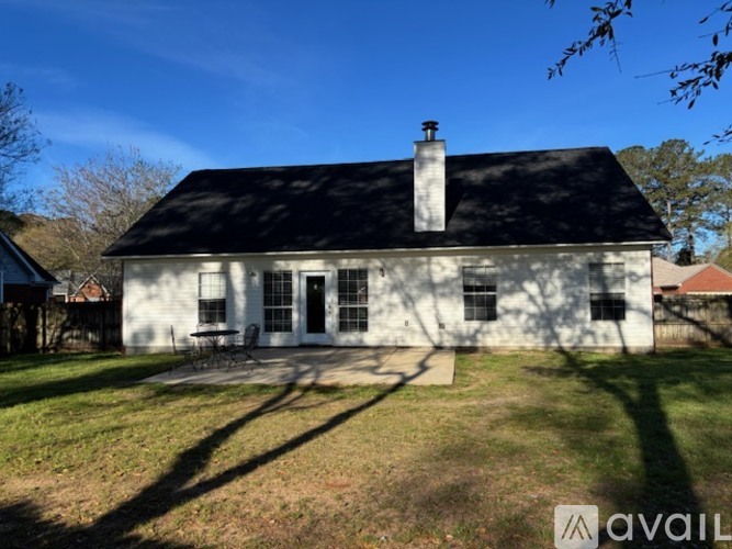 A white house with a black roof and a chimney is available for sale.